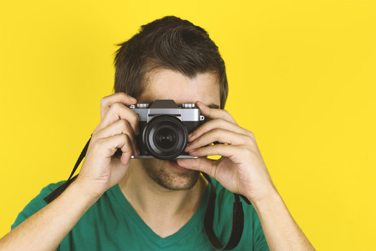 Yong Handsome Man Holding Photo Cavera Isolated On Yellow Background