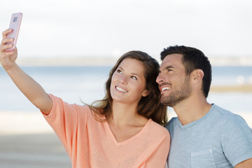 Obraz premium couple taking picture on the beach