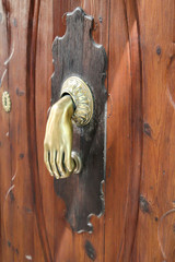 ein alter Türklopfer aus Messing an einer Holztür