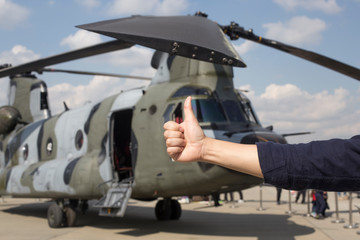 Fototapeta na wymiar Man with thumb up in front of military helicopter