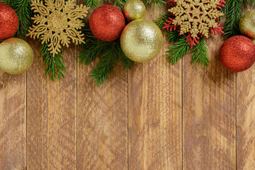 Fototapeta na wymiar Christmas decorations, golden color and red balls on a brown wooden table. Top view, copy space.