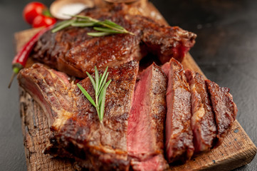 Grilled beef steak with spices on a stone background
