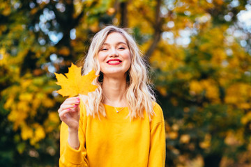 Autumn girl playing in city park. Fall woman portrait of happy lovely and beautiful mixed race Asian Caucasian young woman in forest in fall colors.