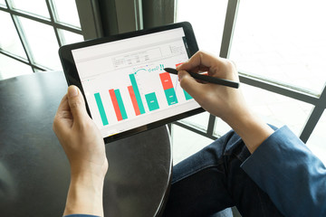 businessman using  drawing comment in tablet for analysis graph visualization at coffee shop