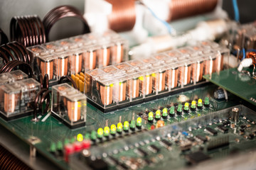 Close-up of a large green microcircuit with wires and plugs connected to it at a military equipment...