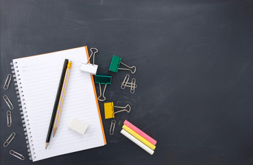 Back to school concept. Top view of blackboard or chalkboard with school supplies. 