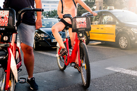 Barcelona, Spain - 20 july 2019: young woman riding a bicing bike in the middle of city traffic on a sunny summer day, a symbol of the millennial sharing economy