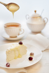 Cup of tea and cake. Sweet curd dessert with berries, poured from a spon with condensed milk.