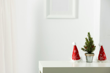 Fototapeta premium Wooden shelf with space for your decoration. White wall with frame picture background. Christmas composition.Winter time. Copy space. 