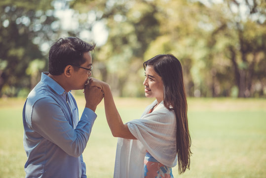 Romantic Couple Standing On Field At Park