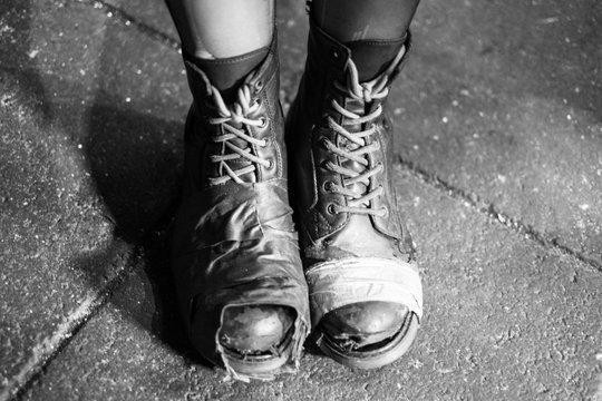 Mit Klebeband provisorische geflickte Schuhe einer jungen Frau in Reykjavik. / Temporarily patched shoes of a young woman in Reykjavik.