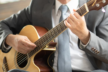 Obraz na płótnie Canvas Midsection Of Businessman Playing Guitar