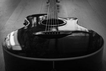 Black acoustic guitar laying on The ground