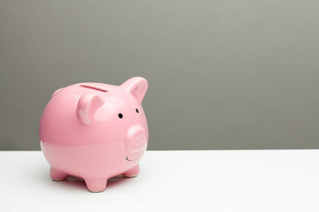Pink piggy bank on a gray background. Copy space for text.