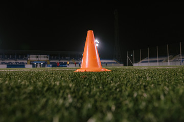 Orange cone for training football on the field