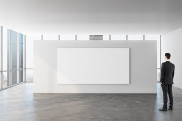 Businessman in gallery with poster