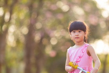 portrait of cute asian girl in park with bokeh nature background.