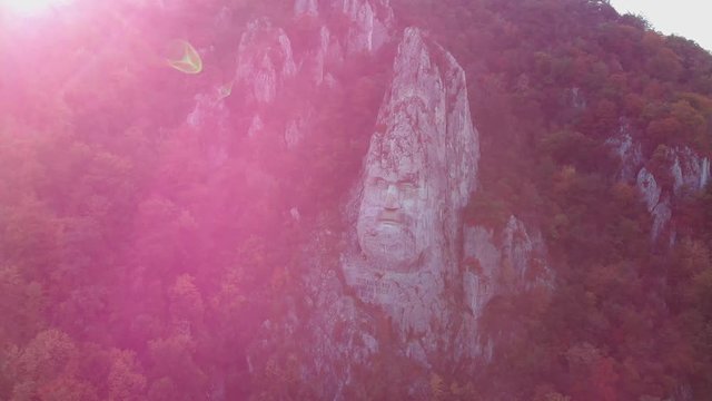 Aerial approch of statue of decebalus, the biggest statue in Europe, with lens flare.