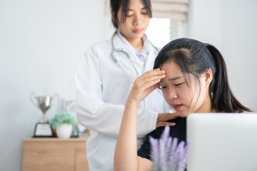 Young patient serious headache siiting on table, Asian female doctor talking for comforting for peace of mind, Medicine student treatment in hospital concept