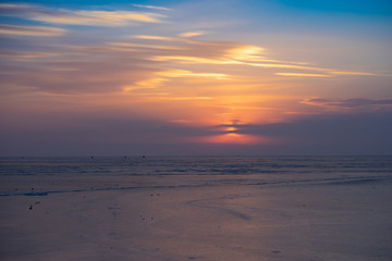 Fototapeta na wymiar Sunset over the frozen surface of the Amur Bay.
