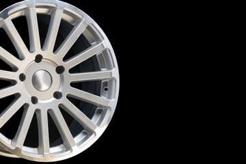 Obraz premium new vehicle rims made from aluminum alloy, multi-spoke silver wheel, close-up on a black background, copy space.