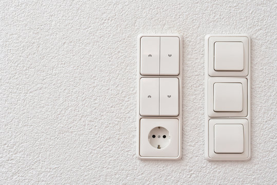 Wall mounted light switches, roller shutter control switch for closing windows and electrical outlet, close-up