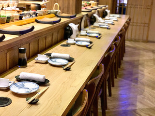 	 Closeup of chef hands preparing japanese food. Japanese Omakase Chef making sushi at restaurant. chef serving traditional japanese sushi with gold served on a stone plate.