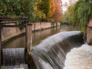 the water of the river gets speed after the jump of a small waterfall. autumn landscape on the outskirts of Milan