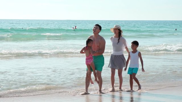 Happy young family having fun on beach,4K