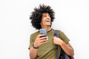 happy young guy with bag and cellphone smiling on isolated white background - obrazy, fototapety, plakaty