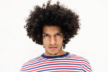 Close up front portrait handsome young North African man with afro hairstyle and serious face...