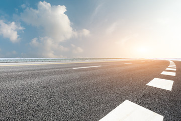 Country road and farmland snow scene at sunset