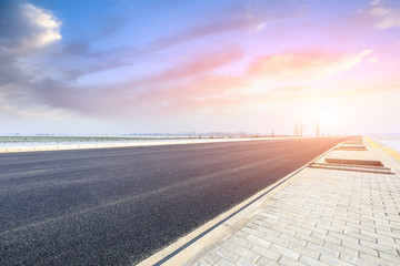 Country road and farmland snow scene at sunset