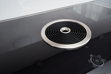 Modern induction cooker with a black glass surface and integrated hood in the kitchen