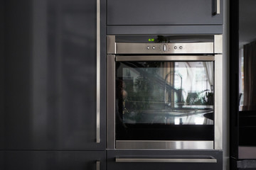 Obraz premium Metallic oven in the interior of a dark gray kitchen