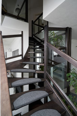 Steps of dark wooden staircase with anti-slip mat surface