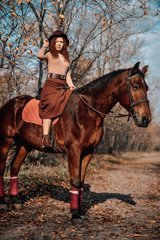 Fototapeta premium Beautiful red haired woman posing on horse outdoor.