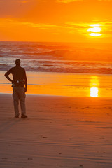 Fototapeta na wymiar Friend on Oregon beach, watching sunset.