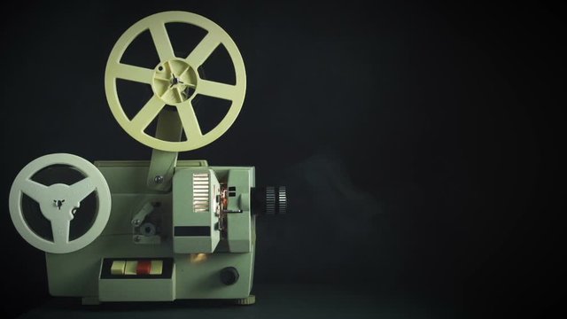 Vintage film projector with dramatic light. Old cinema projector on black background.