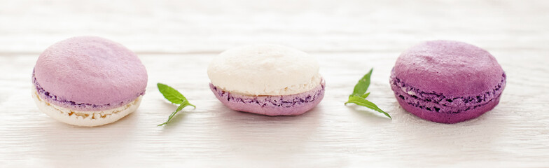 Obraz na płótnie Canvas French cookies. Purple macaroons. White wooden background.