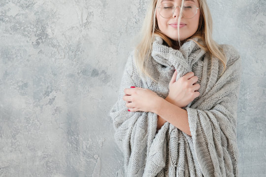 Cold Season Comfort. Happy Lady In Warm Cozy Gray Knitted Blanket.