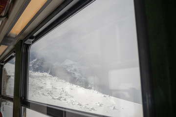 Beautiful window view of snow mountain with foggy for background with copy space, Jungfrau,...