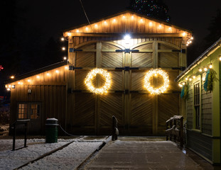 Barn house decorated with christmas lights photographed on a winter night, this wreath stands out...