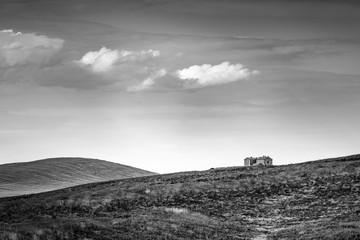 Beautiful Tuscany b&w landscape with isolated house and clouds