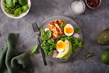 healthy keto paleo diet breakfast: boiled egg, avocado, halloumi cheese, salad leaves