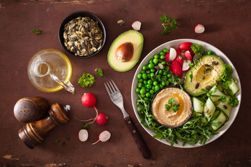 Fototapeta na wymiar healthy vegan lunch bowl with avocaco cucumber hummus peas radish