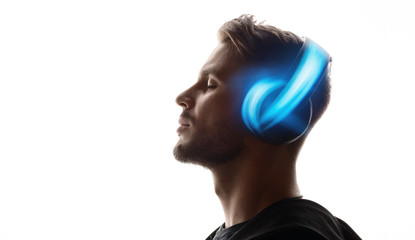 Portrait of man in headphones listening music with closed eyes. White background. Blue neon light.