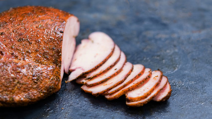 Grill restaurant menu. Closeup of sliced smoked turkey breast on kitchen table. Copy space.