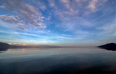 The gentle colors of the lake and the cloudy sky before sunset. Kerkini, Greece.