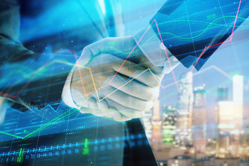 Double exposure of financial chart on cityscape background with two businessmen handshake. Concept of financial analysis and investment opportunities